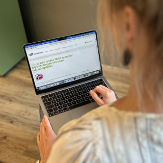 Vrouw kijkt naar laptop