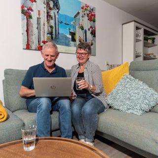 Echtpaar op bank met laptop