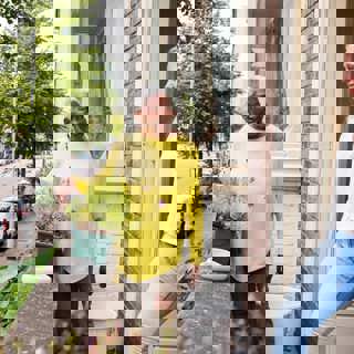 Onder de pannen foto 2 personen bij een woning